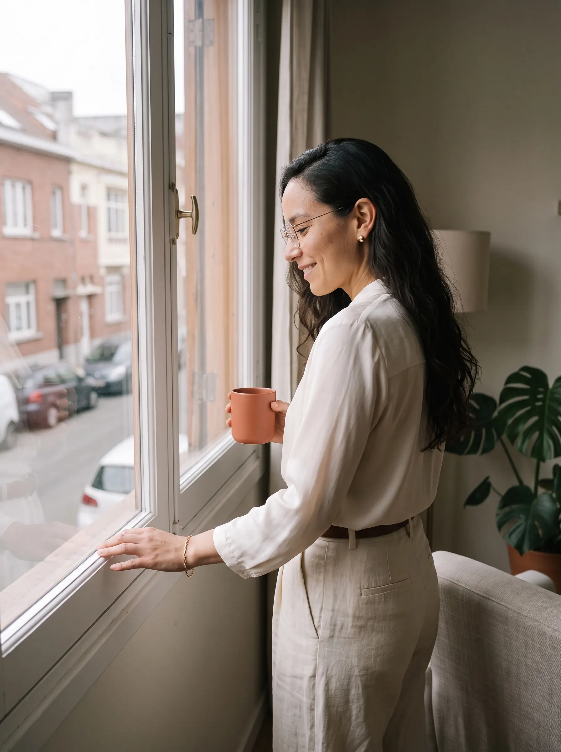 Psicóloga con una taza de café junto a la ventana antes de empezar su jornada